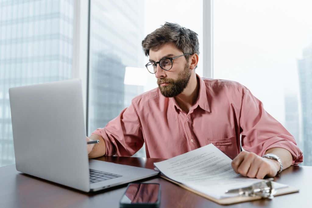 Trader looking at his laptop where he keeps a journal for trading to monitor trade feedback - TradeZella